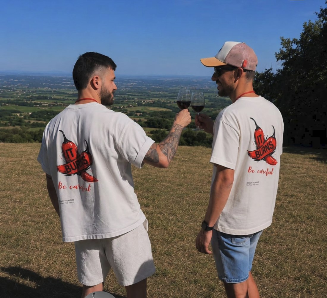 Maxime et Hugo, fondateurs de Crazy Tongue, trinquant au vin dans le Beaujolais en tee-shirts It Burns